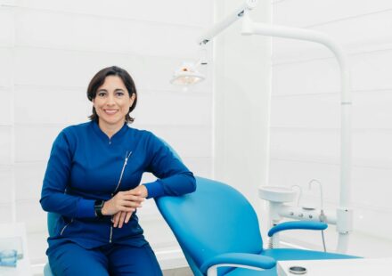 Smiling female dentist sitting in a modern clinic, ready for patients