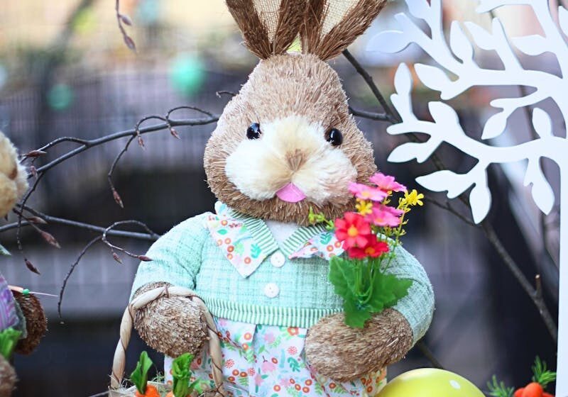Adorable Easter bunny decoration with vibrant flowers and a carrot-filled basket.