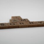 Scrabble tiles on white background forming the words 'I Am Sorry.' Ideal for conveying apologies or communication concepts.