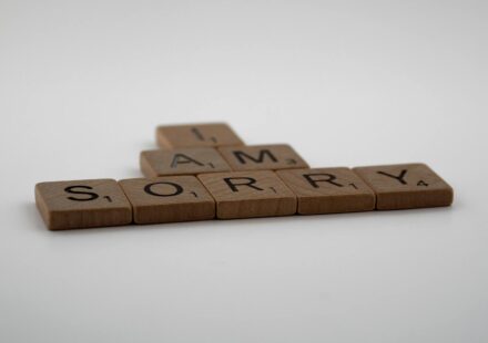 Scrabble tiles on white background forming the words 'I Am Sorry.' Ideal for conveying apologies or communication concepts.