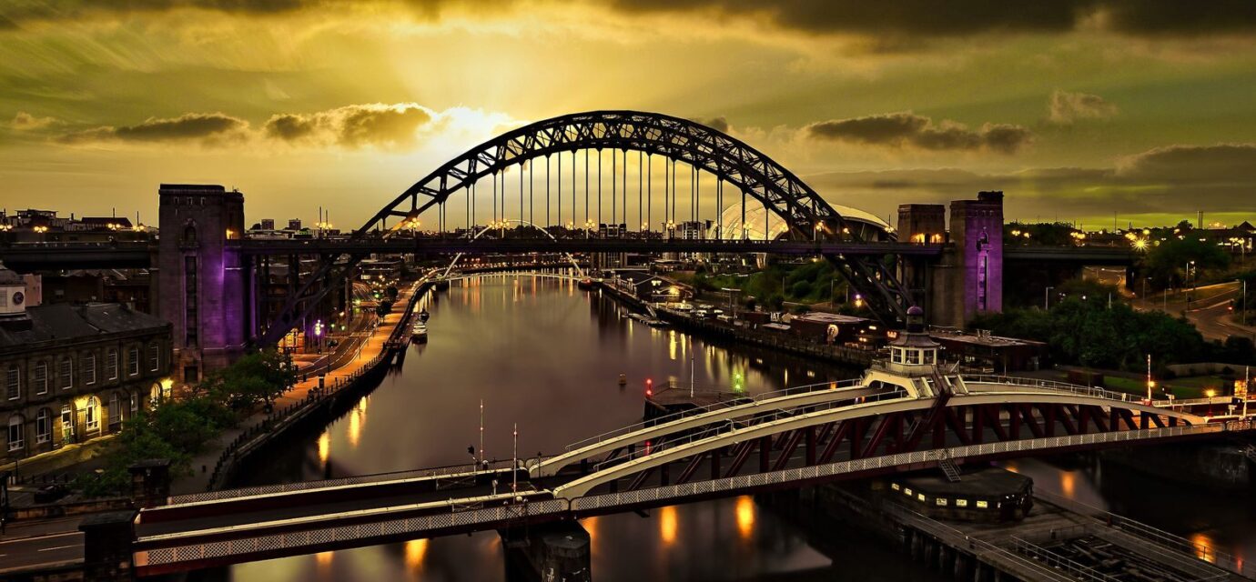 A captivating sunset view of the Tyne Bridge in Newcastle with vibrant reflections on the river.