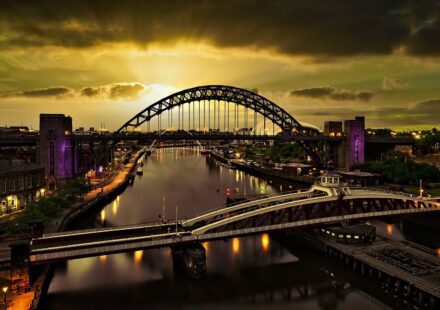A captivating sunset view of the Tyne Bridge in Newcastle with vibrant reflections on the river.