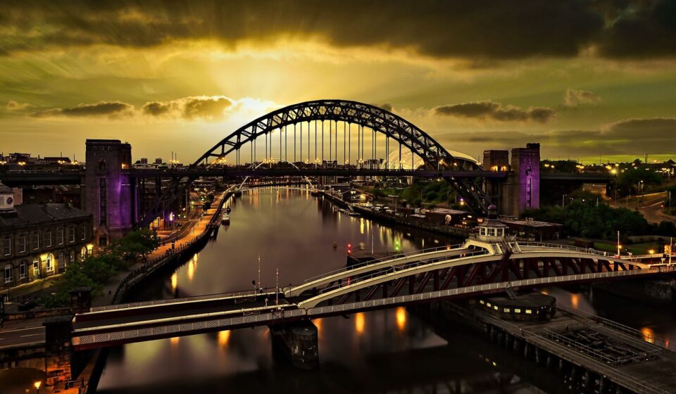 A captivating sunset view of the Tyne Bridge in Newcastle with vibrant reflections on the river.