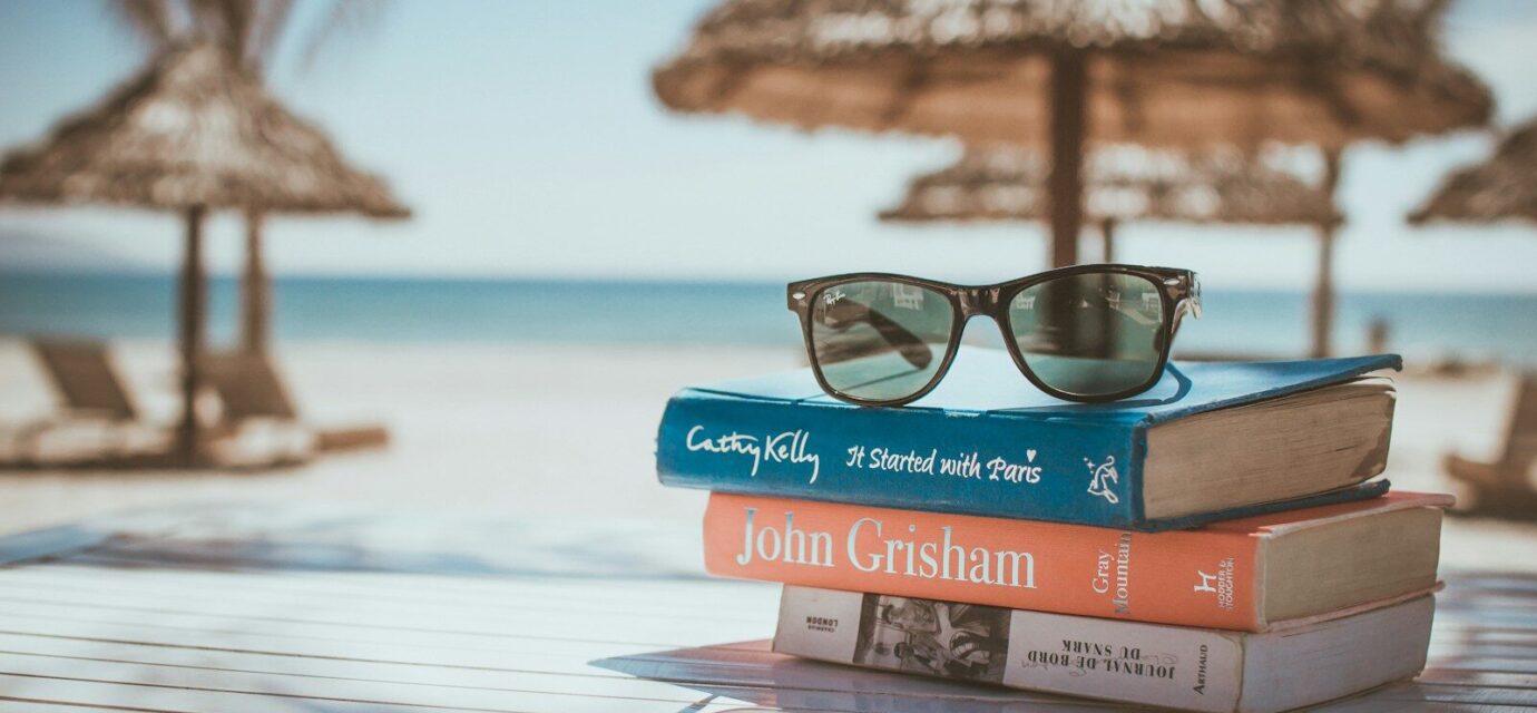 black framed Ray-Ban Wayfarer sunglasses on top of book