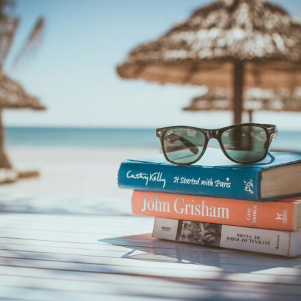 black framed Ray-Ban Wayfarer sunglasses on top of book